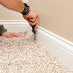 Carpet installer installing carpet