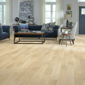 Bright living room with pale oak hardwood flooring and navy blue velvet furniture.