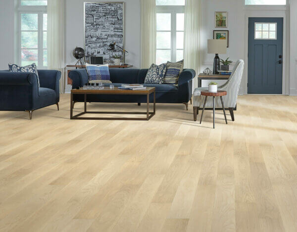 Bright living room with pale oak hardwood flooring and navy blue velvet furniture.